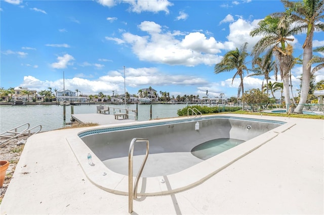 view of swimming pool featuring a dock, a water view, and a jacuzzi