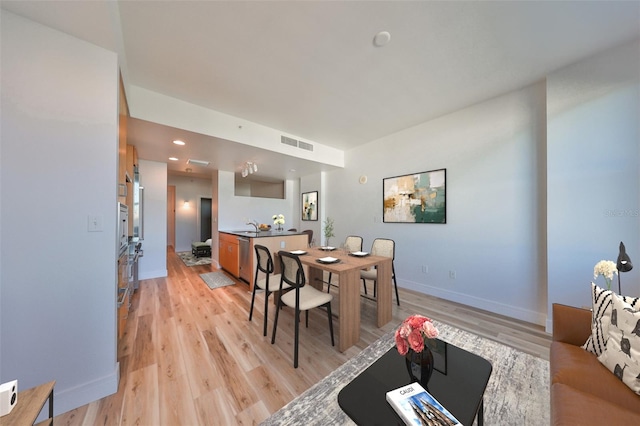 dining room with light wood-type flooring and sink