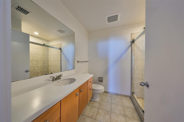 bathroom featuring tile patterned flooring, vanity, toilet, and walk in shower