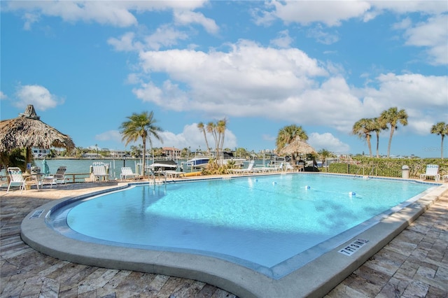 view of pool with a water view and a patio area