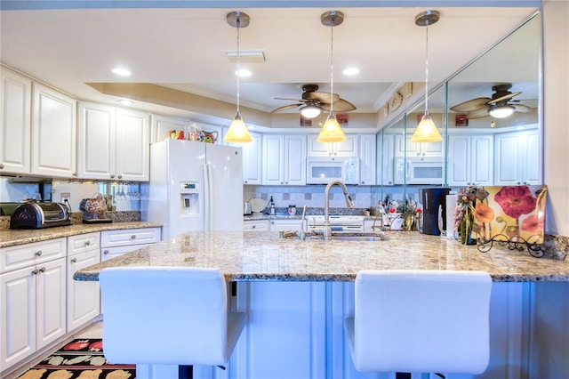 kitchen featuring white cabinets, white appliances, and hanging light fixtures