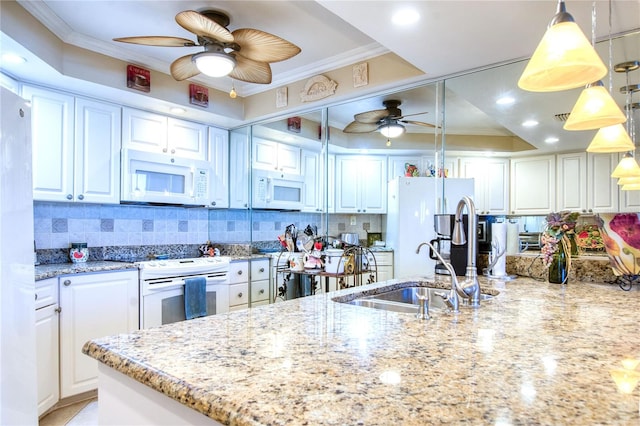 kitchen featuring white appliances, white cabinetry, hanging light fixtures, and sink