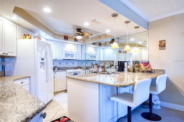 kitchen featuring light stone counters, ornamental molding, white appliances, ceiling fan, and white cabinetry