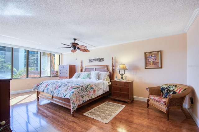 bedroom featuring ceiling fan, crown molding, wood-type flooring, and a textured ceiling