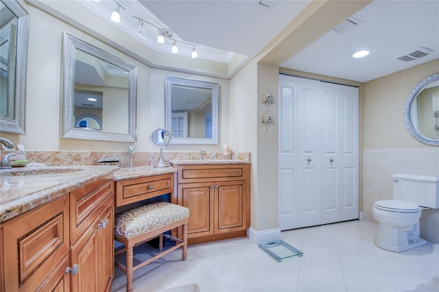 bathroom featuring vanity, crown molding, tile patterned flooring, toilet, and tile walls