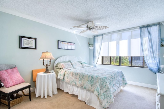 bedroom featuring ceiling fan, light colored carpet, a textured ceiling, and ornamental molding