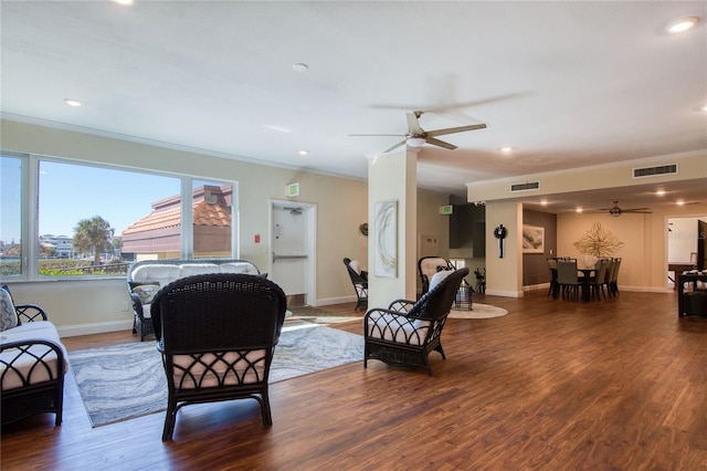 living room featuring hardwood / wood-style flooring, ceiling fan, and ornamental molding