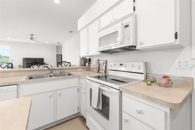 kitchen with white appliances, sink, kitchen peninsula, ceiling fan, and white cabinetry