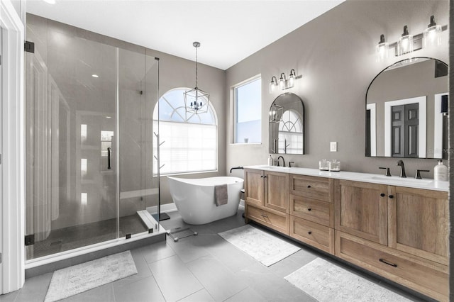 bathroom featuring tile patterned flooring, shower with separate bathtub, vanity, and an inviting chandelier