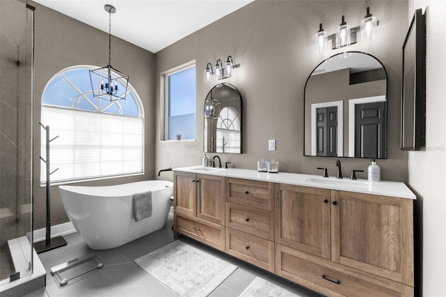 bathroom featuring a notable chandelier, plenty of natural light, separate shower and tub, and vanity