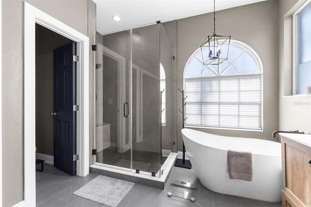 bathroom with tile patterned flooring, vanity, separate shower and tub, and a notable chandelier