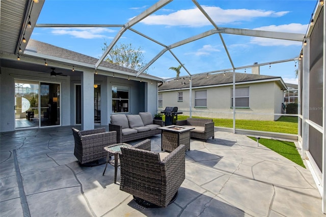 view of patio featuring a lanai, area for grilling, ceiling fan, and an outdoor hangout area