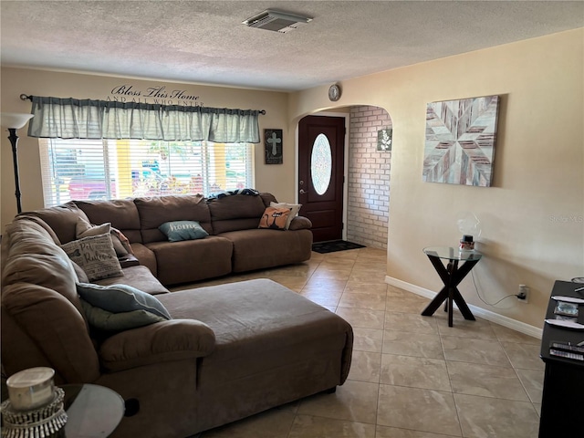 living room featuring a textured ceiling and light tile patterned floors