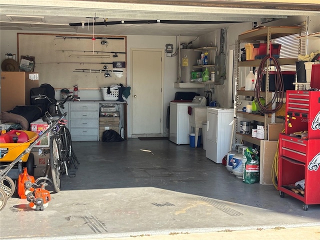 garage featuring a workshop area, washing machine and dryer, and water heater