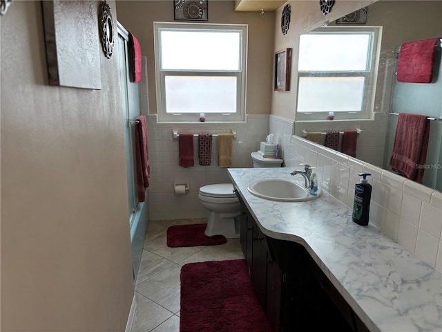 bathroom with vanity, toilet, tile patterned flooring, and tile walls