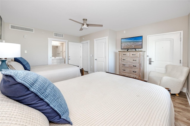 bedroom with light wood-type flooring, ensuite bathroom, and ceiling fan