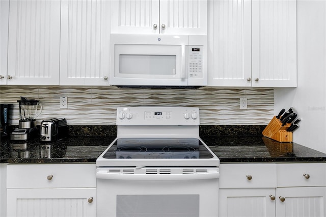 kitchen featuring backsplash, dark stone countertops, white cabinetry, and white appliances