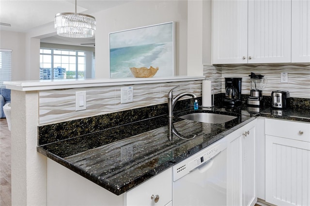 kitchen with pendant lighting, dishwasher, white cabinets, and sink