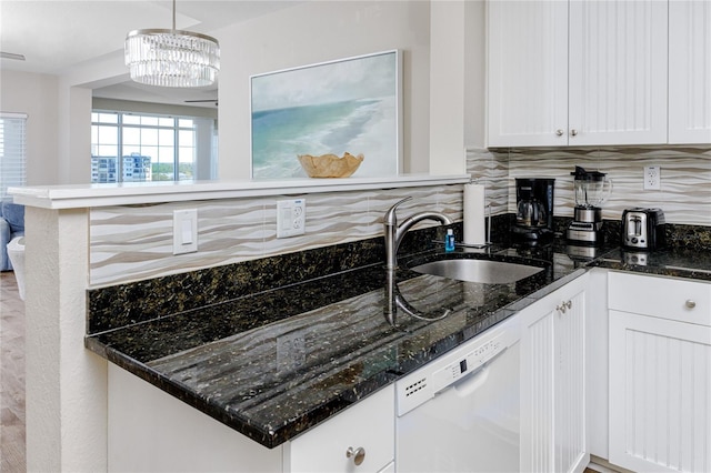 399 2nd St Unit 718, Indian Rocks Beach, FL 33785 - kitchen with white dishwasher, a sink, tasteful backsplash, white cabinetry, and dark stone countertops