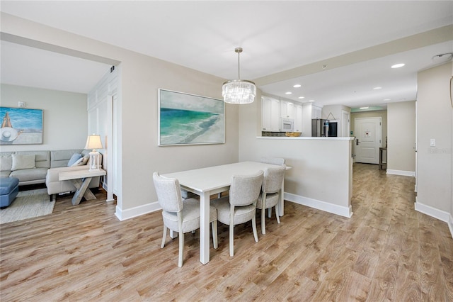 dining room with a chandelier and light hardwood / wood-style floors