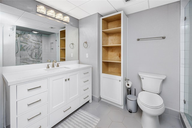 bathroom featuring tile patterned flooring, vanity, toilet, and a tile shower