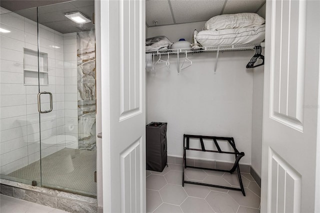 399 2nd St Unit 718, Indian Rocks Beach, FL 33785 - full bath featuring tile patterned flooring, a spacious closet, a shower stall, and baseboards