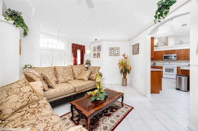 tiled living room featuring ceiling fan and ornamental molding