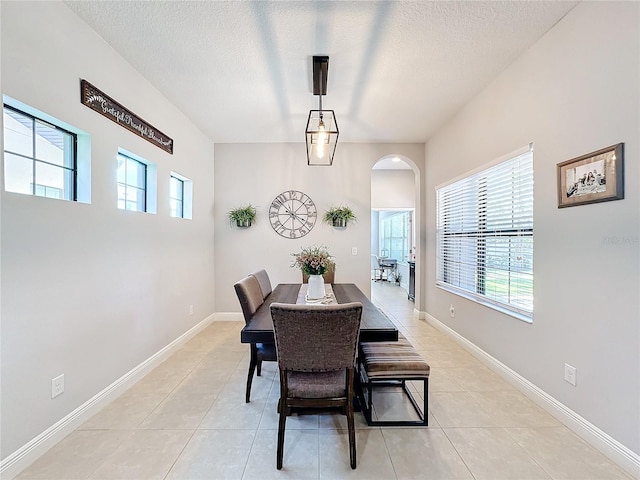 dining area featuring light tile patterned floors and a textured ceiling