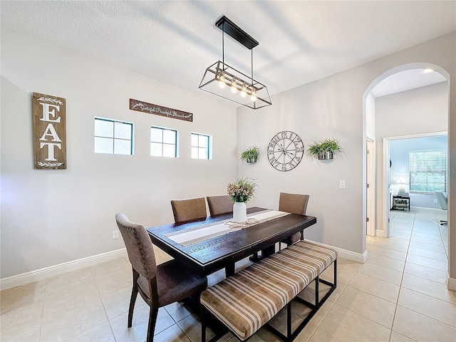 dining area featuring light tile patterned floors and a textured ceiling