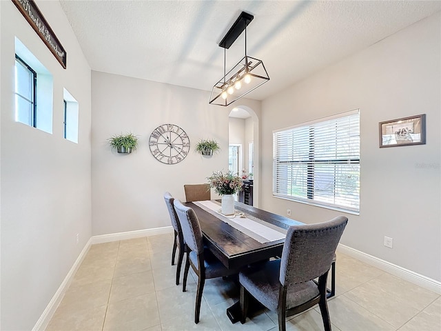 tiled dining room featuring a textured ceiling