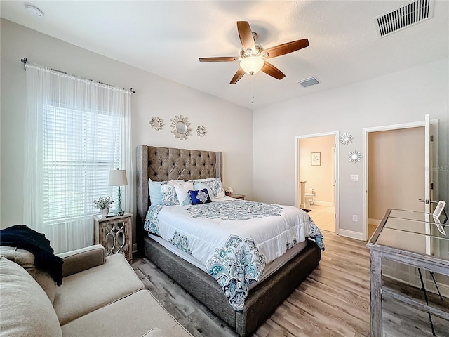 bedroom featuring ensuite bath, ceiling fan, and light wood-type flooring