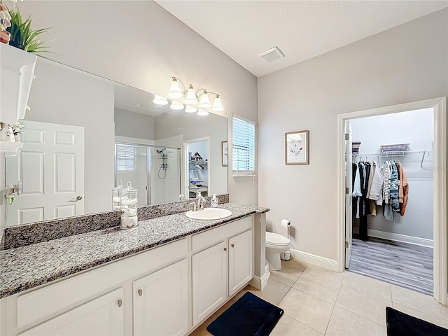 bathroom with tile patterned flooring, plenty of natural light, an enclosed shower, and vanity