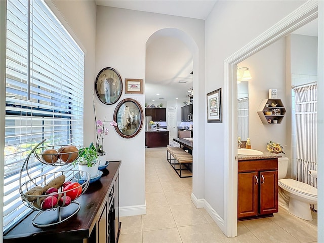 hallway featuring light tile patterned floors and sink