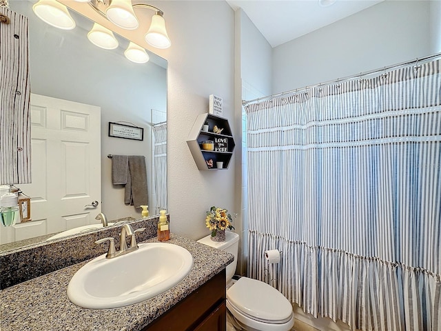 bathroom featuring a shower with shower curtain, vanity, and toilet