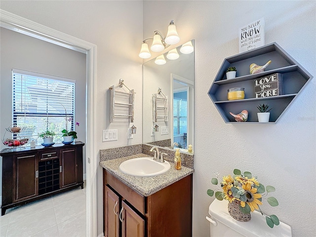 bathroom with toilet, vanity, and tile patterned floors