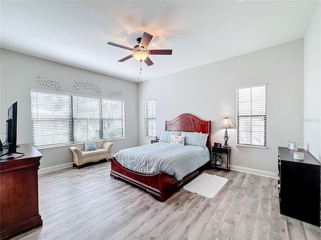 bedroom featuring ceiling fan, a textured ceiling, and light wood-type flooring