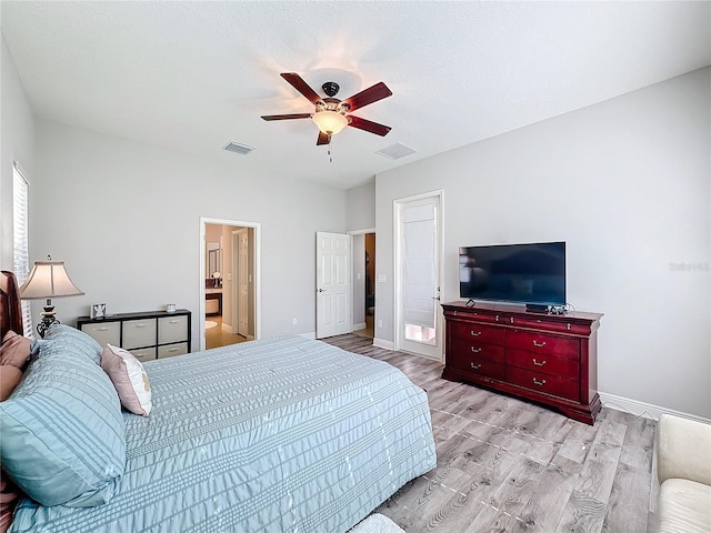 bedroom with ceiling fan, ensuite bath, and light hardwood / wood-style flooring