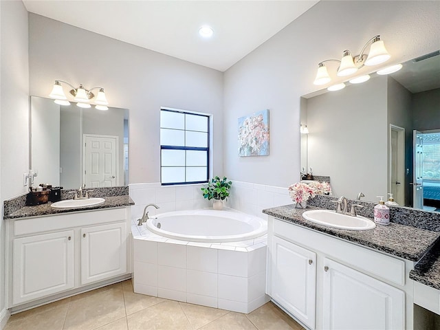 bathroom featuring tile patterned floors, vanity, and a relaxing tiled tub