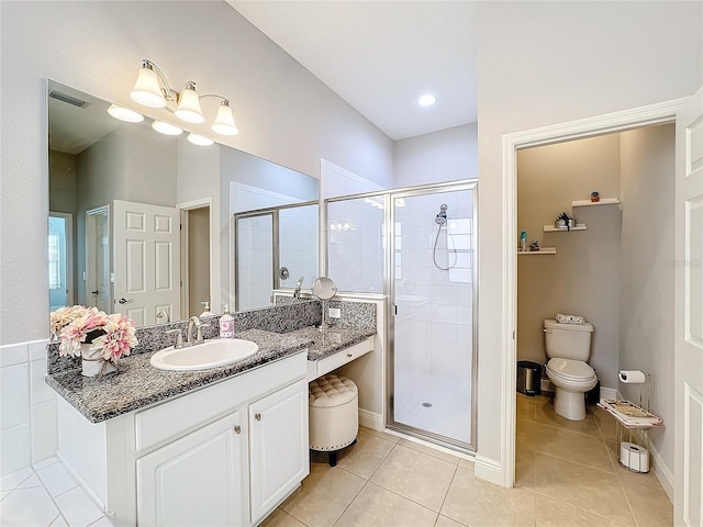 bathroom featuring tile patterned flooring, vanity, toilet, and an enclosed shower