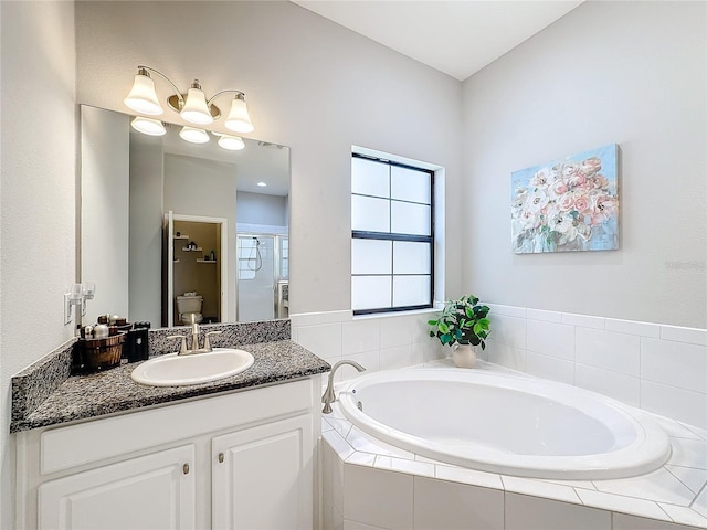 full bathroom featuring vanity, toilet, and independent shower and bath