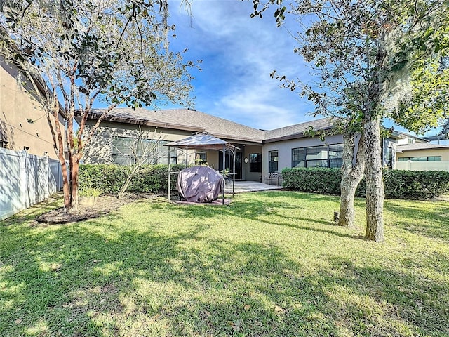 back of house featuring a lawn and a patio