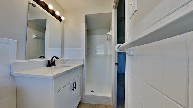 bathroom with vanity and tiled shower