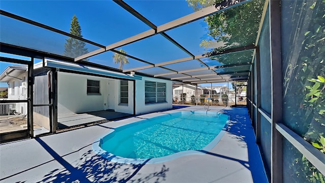 view of pool featuring glass enclosure and a patio