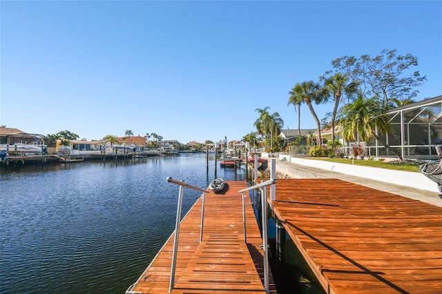 dock area with a lanai and a water view