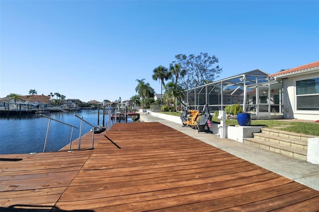 view of dock with glass enclosure and a water view