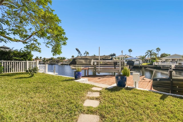 dock area featuring a water view and a lawn