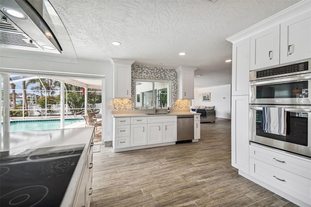 kitchen featuring dark wood-type flooring, sink, white cabinets, and stainless steel appliances