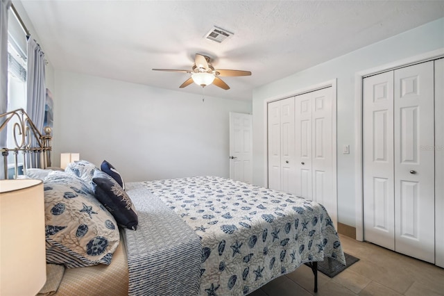 bedroom featuring ceiling fan and multiple closets