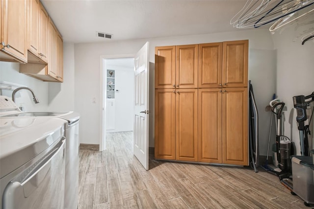 kitchen with independent washer and dryer and light wood-type flooring