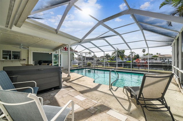 view of swimming pool featuring a water view, glass enclosure, ceiling fan, and a patio area